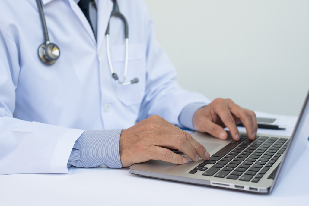 Healthcare professional working on laptop on a white desk