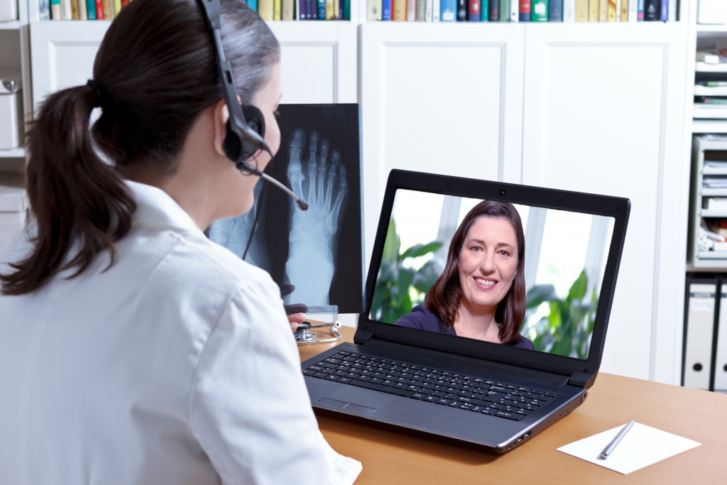 doctor diagnosing the health of her patient via video conference call