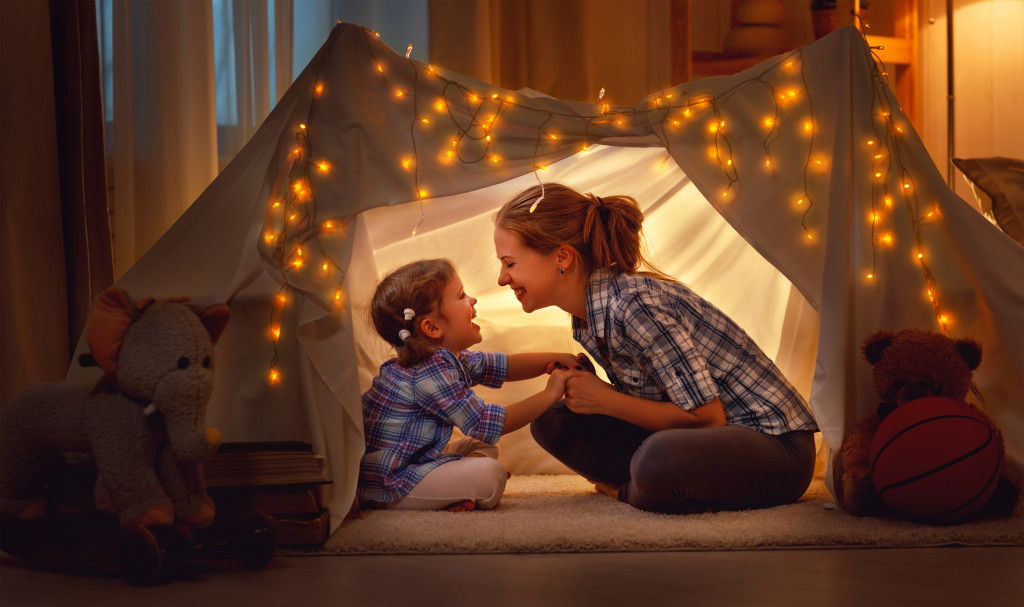 mother and daughter in a blanket tent