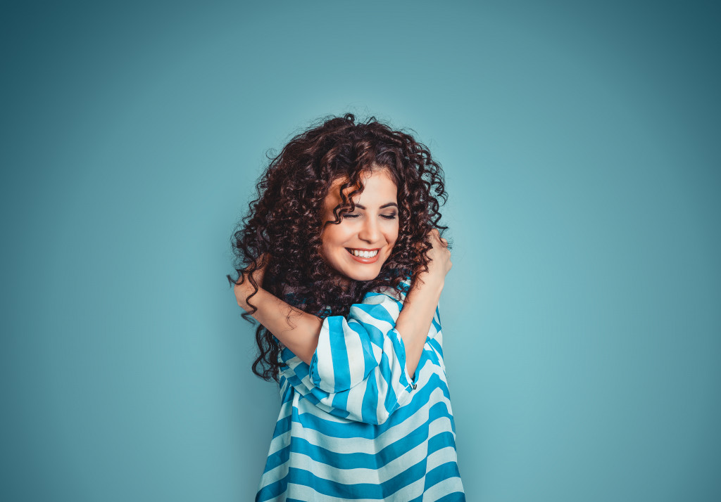woman in blue stripes hugging herself