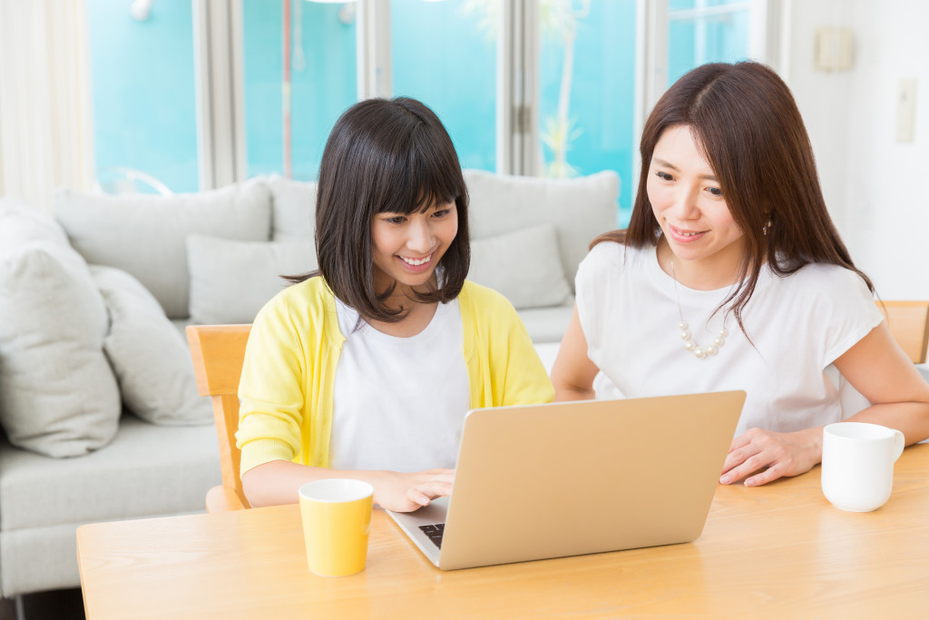 mother and daughter looking at a laptop screen