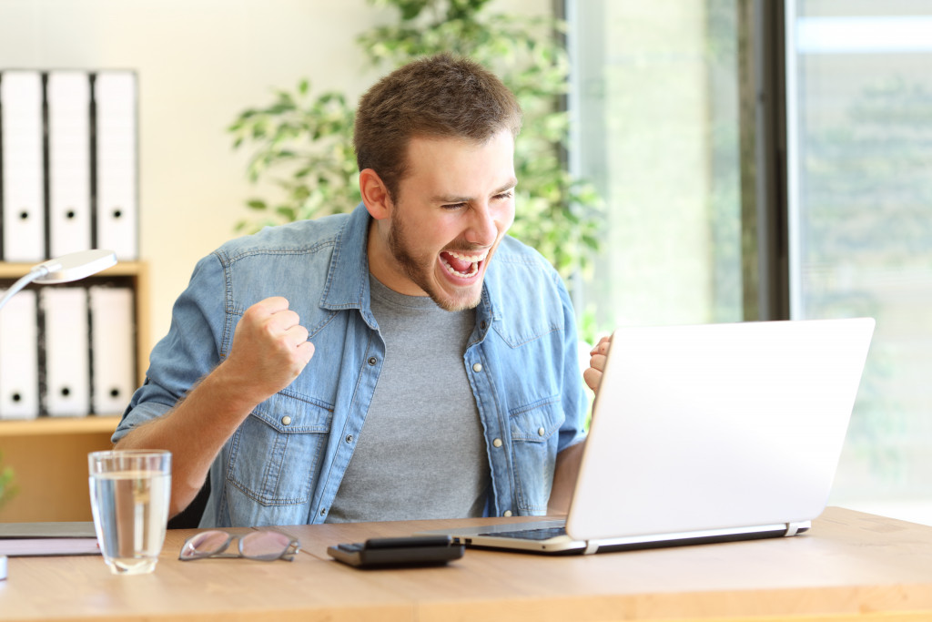 Man reacting to something good they see on his laptop's screen