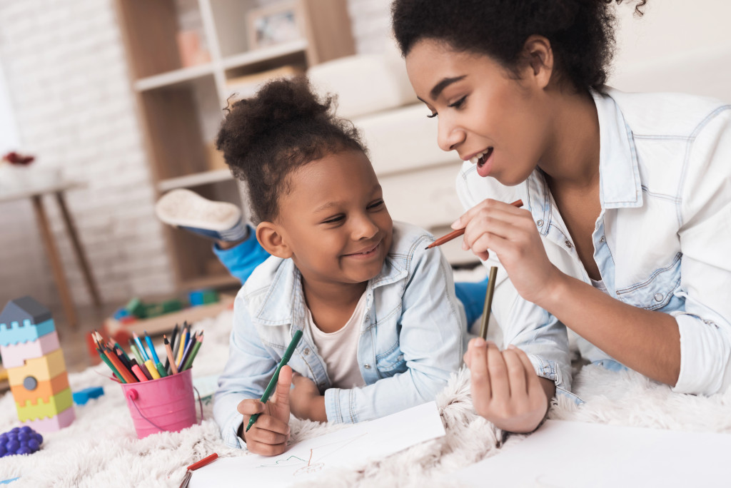 mother teaching her daughter how to draw