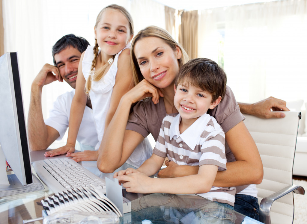 family smiling while son is using the computer
