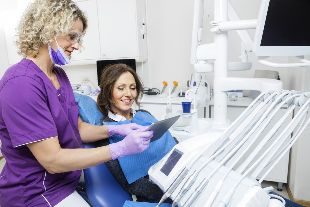 woman looking at tablet with dentist