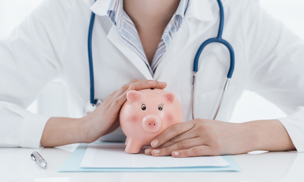 a doctor holding a piggy bank