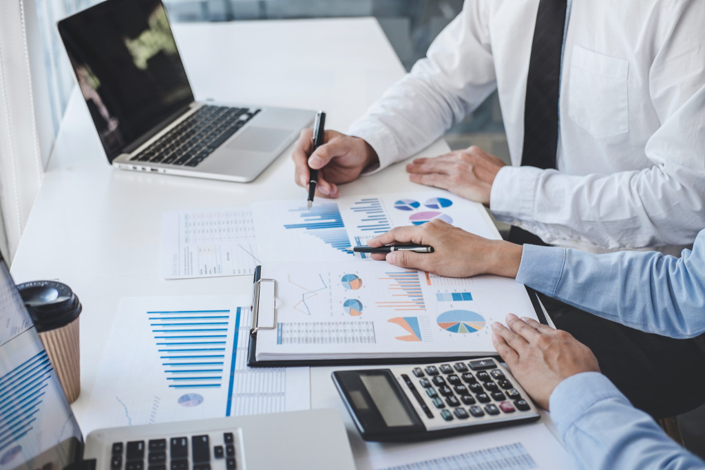 Tow business colleagues analyzing a financial document on a table.