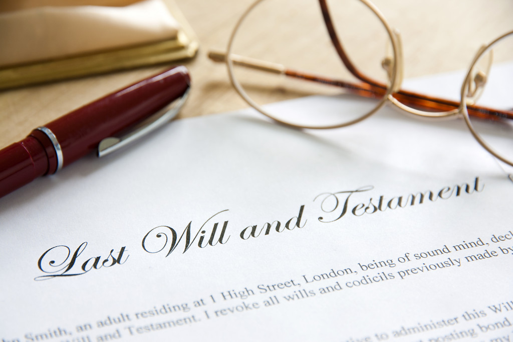 A hard copy of last will and testament, a pen, and glasses
