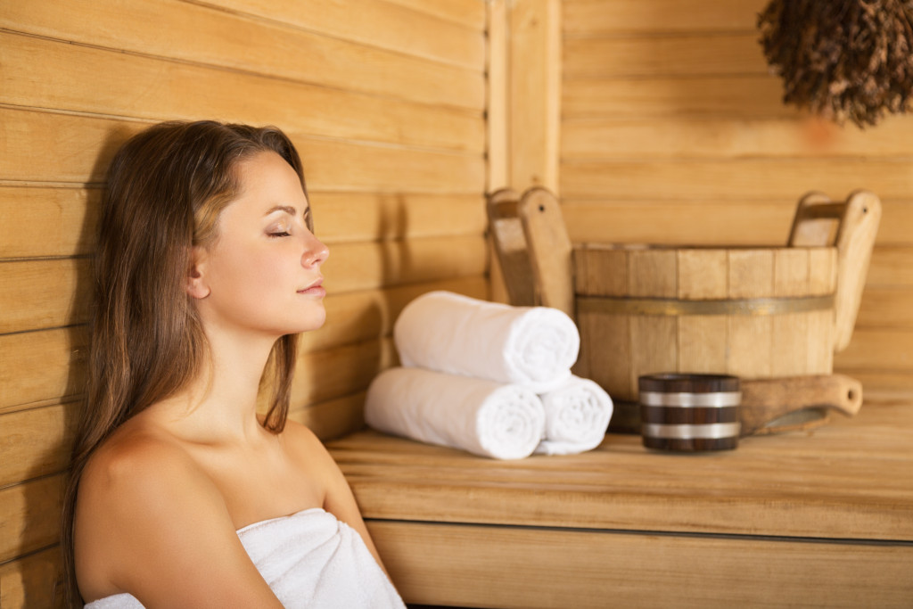 A young woman sitting in a sauna