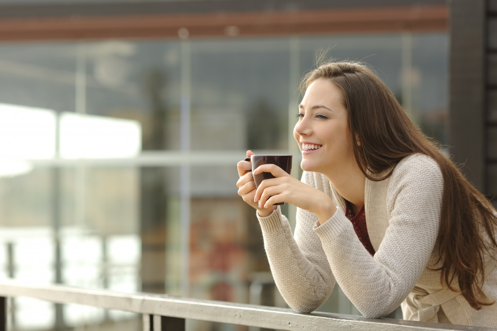 Woman drinking coffee while on the balcony