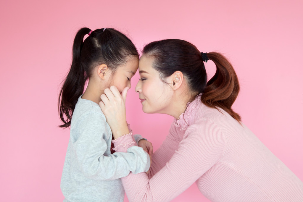 Mother comforting her daughter in the house.