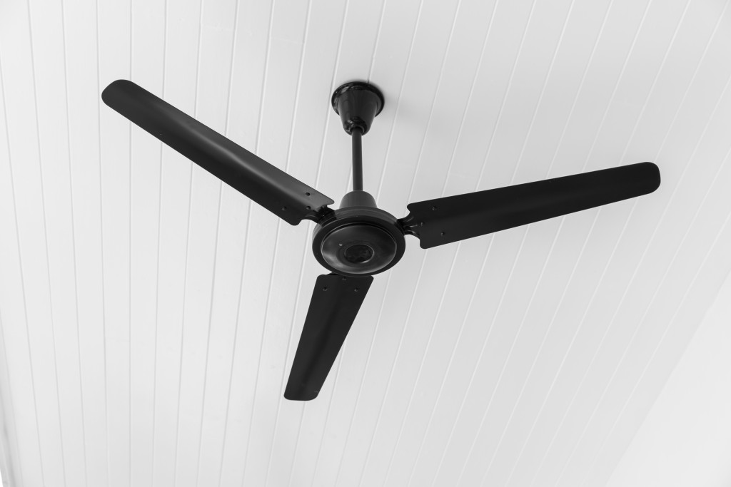 A black ceiling fan on a white ceiling