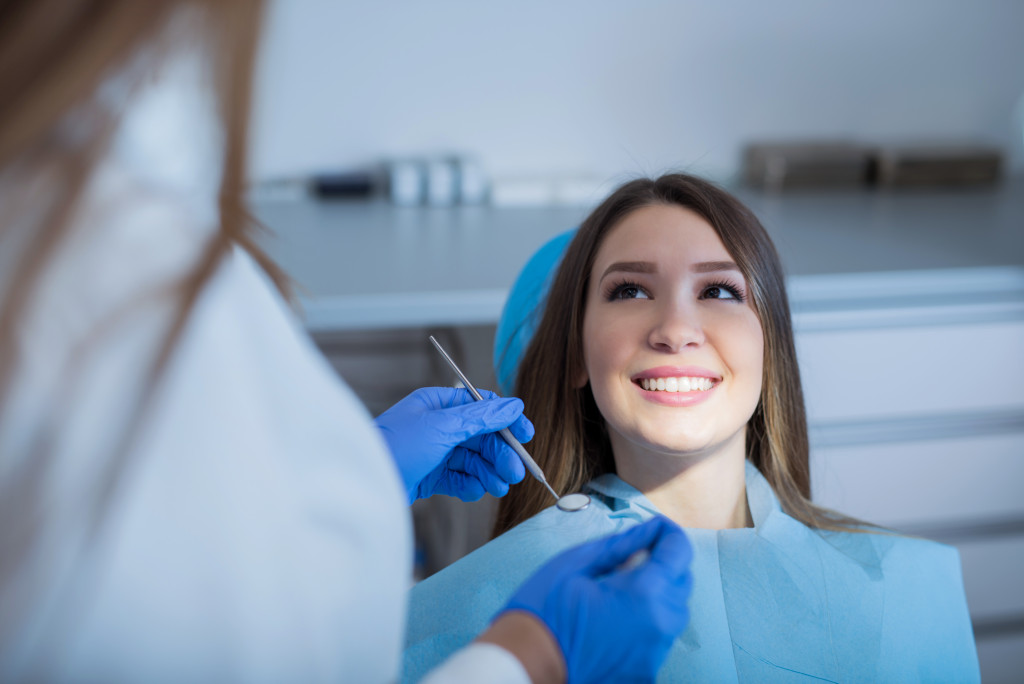 a young woman sitting in a dental chair about to get treatment