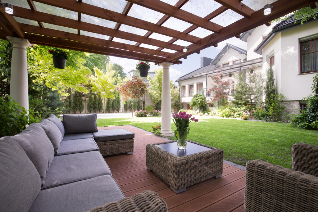 An outdoor look of a house with a seating area under a pergola.