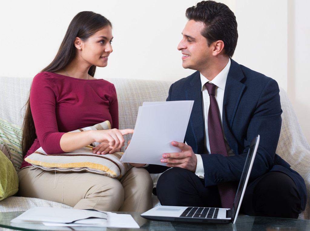 a woman pointing at a document while talking to a professional 