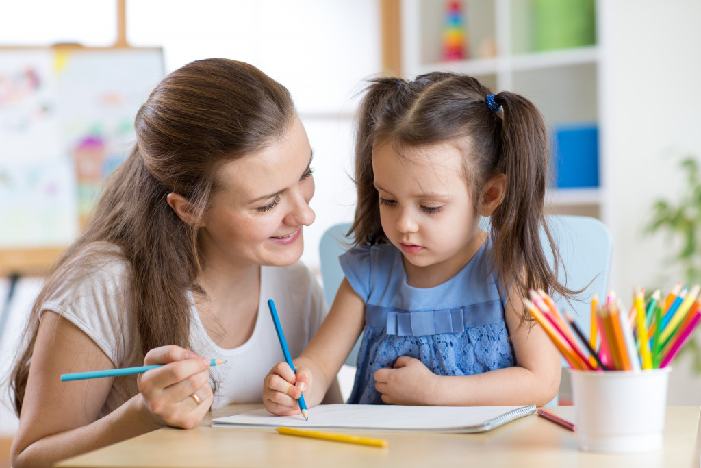 female baby sitter teaching a child to write