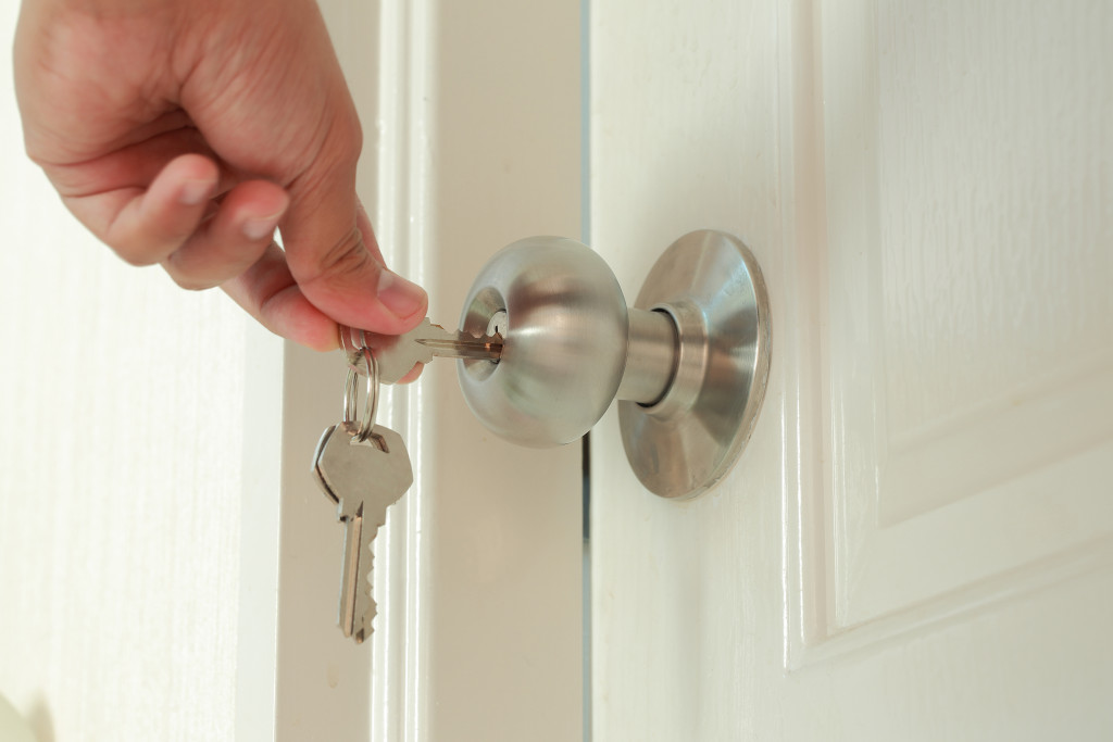 View of a man hand locking door with key