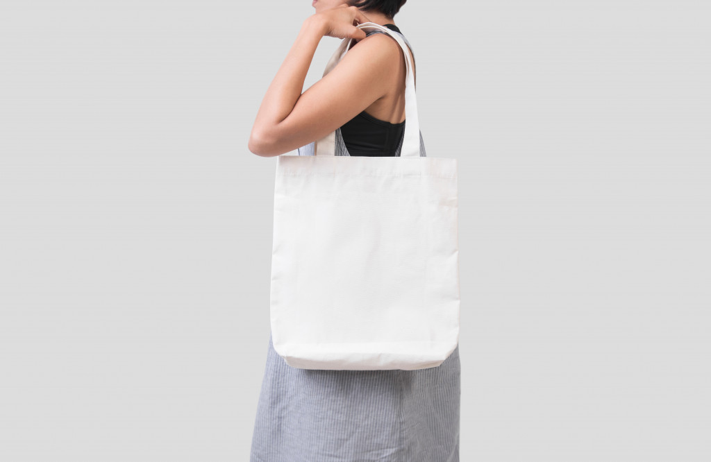 A woman holding a white canvas bag