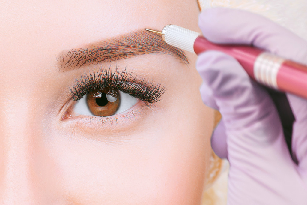 a woman having her eyebrow shaped in the salon