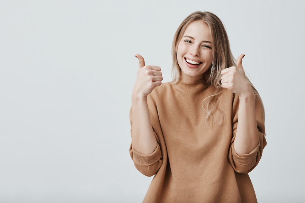 woman thumbs up happy