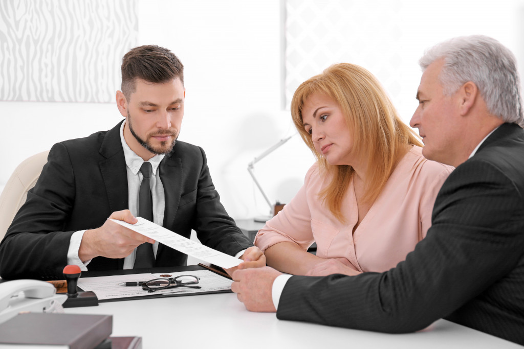 a male adjuster talking to a couple