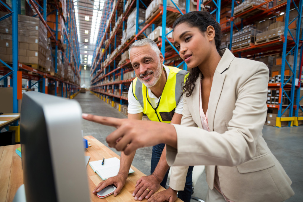 a businesswoman providing instructions to a staff in the warehouse