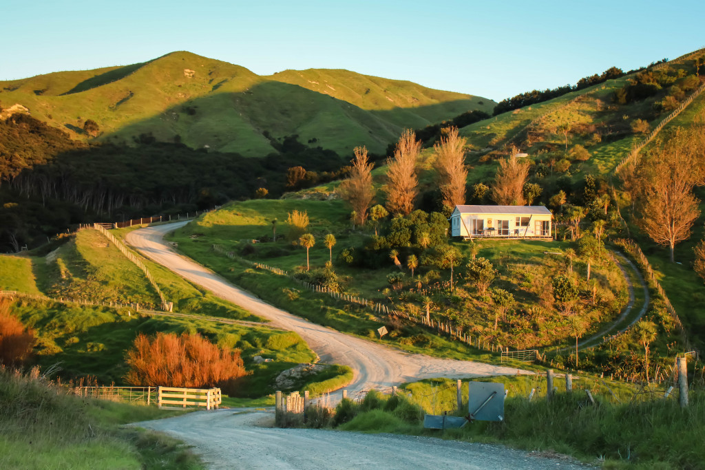 A countryside house on a hill with a winding road