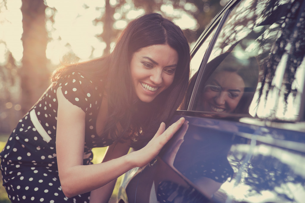 A Woman Checking Car Exterior Cleanliness