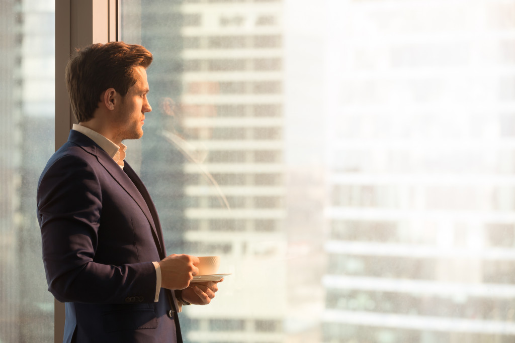 man standing up while having coffee