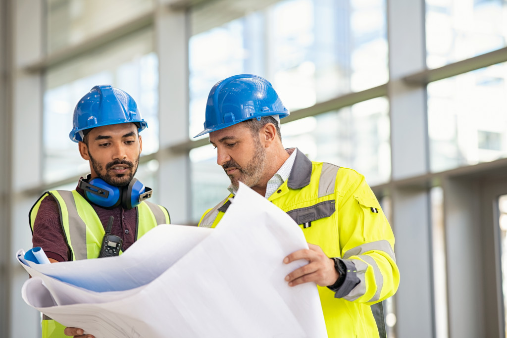 A worker and engineer discussing a plan at a new construction site