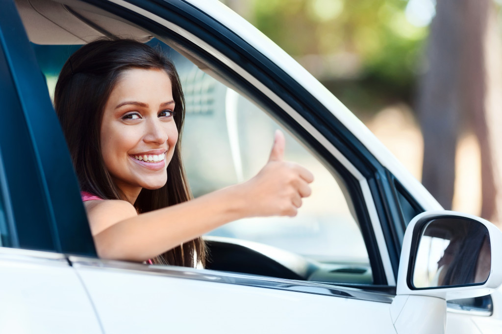 woman thumbs up inside the car